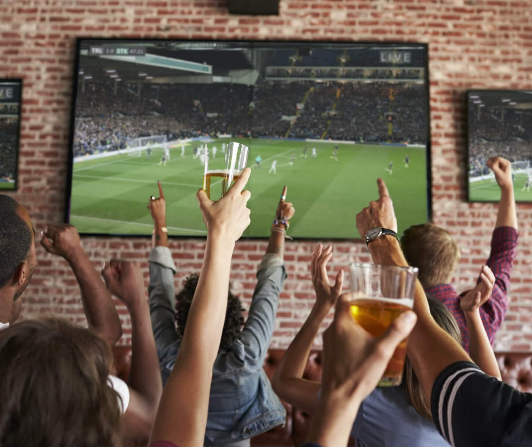 People watching soccer game at bar.