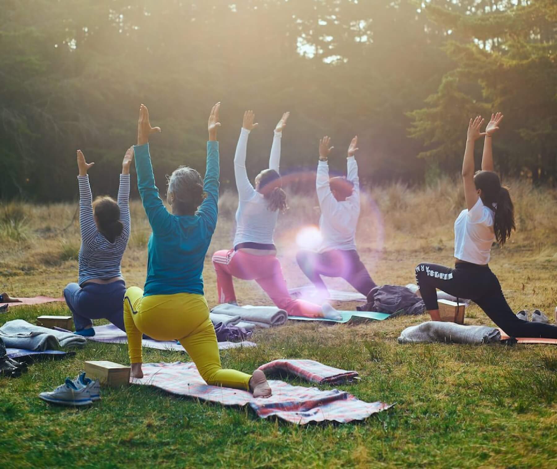 People doing yoga in the park.